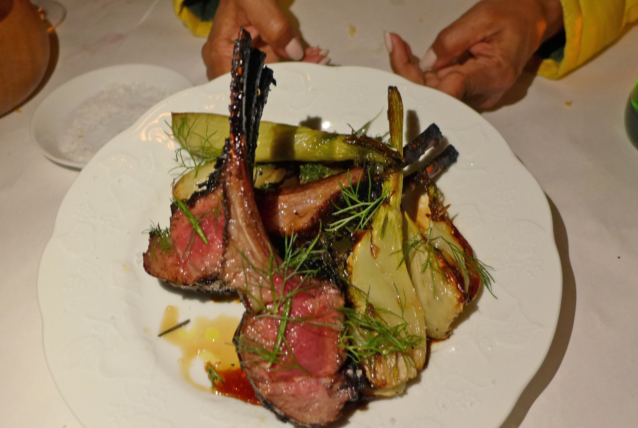 Juicy pink lamb chops with their bones pointing upright.