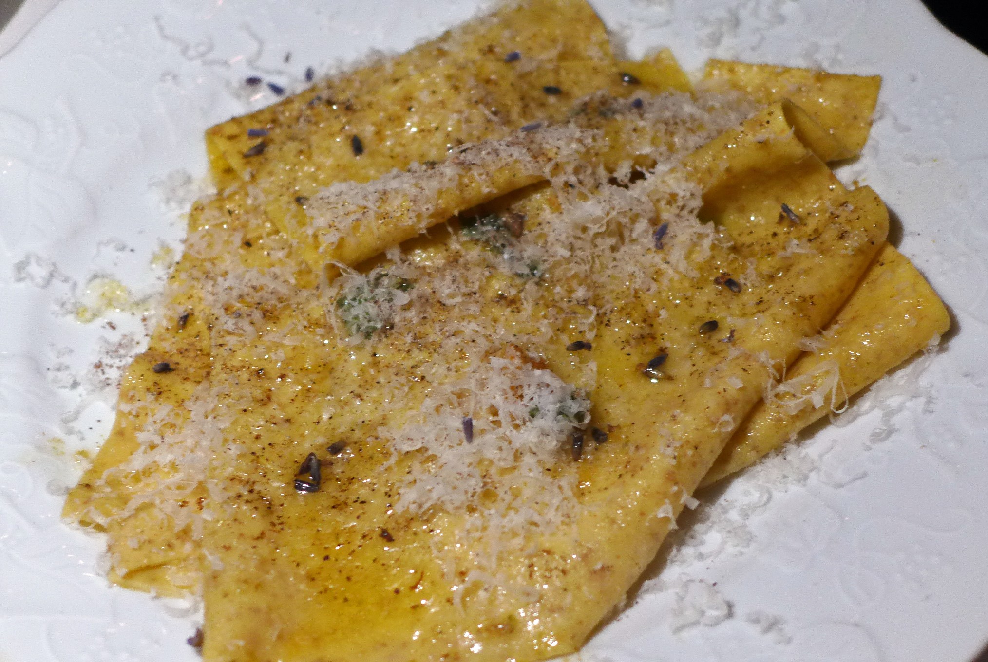 Sheets of pasta loosely folded over each other with sprinklings of cheese.