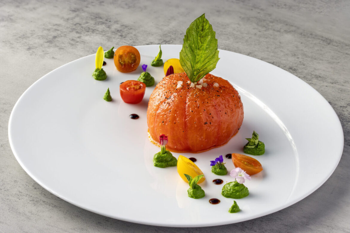 Glittering New River Oaks Restaurant’s French Chefs Are Having Fun — Cocody Is Full of High-End Pleasures, Gourmet Lollipops Included Cocody plays up the classic combination of tomato and burrata cheese, blanching a whole tomato, peeling it, and filling its cavity with imported Italian burrata, a sliver of tomato (sun-dried to concentrate its flavor), and adorned the plate with fried basil leaves, heirloom cherry tomatoes, and dollops of basil pesto ($19). (Photo by Mickael Zibi )