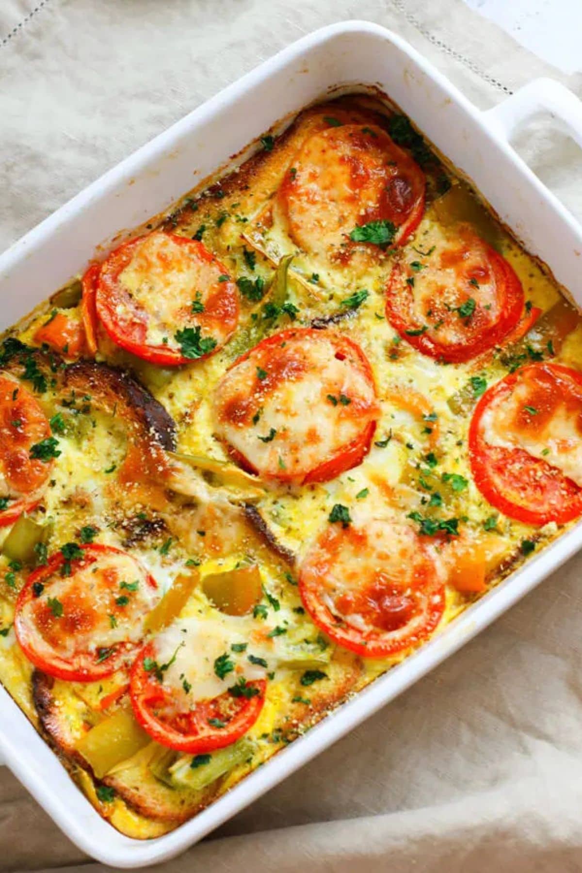 These 35 Scrumptious Make Ahead Brunch Casseroles will make your life over the holidays so much easier. Plus, everyone will be delighted with any one of these casseroles for the holidays. Tomato egg casserole in dish.