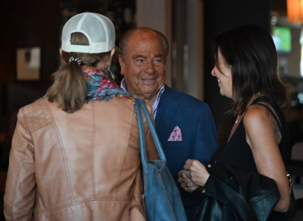 Michael Dene, center, talks with customers at Michael’s on Naples...