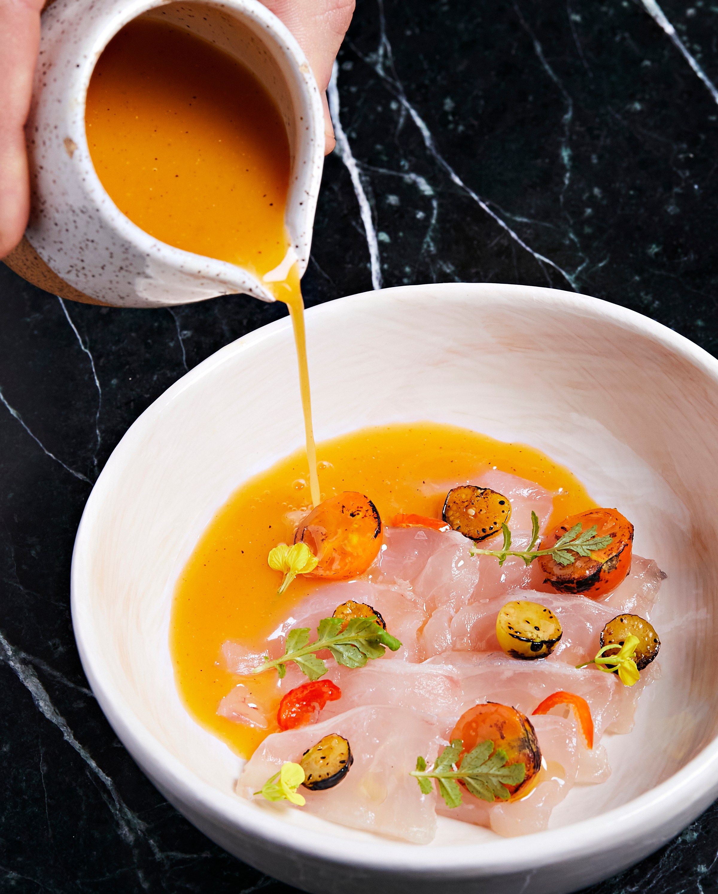 A vibrant crudo dressed with a tableside pour.