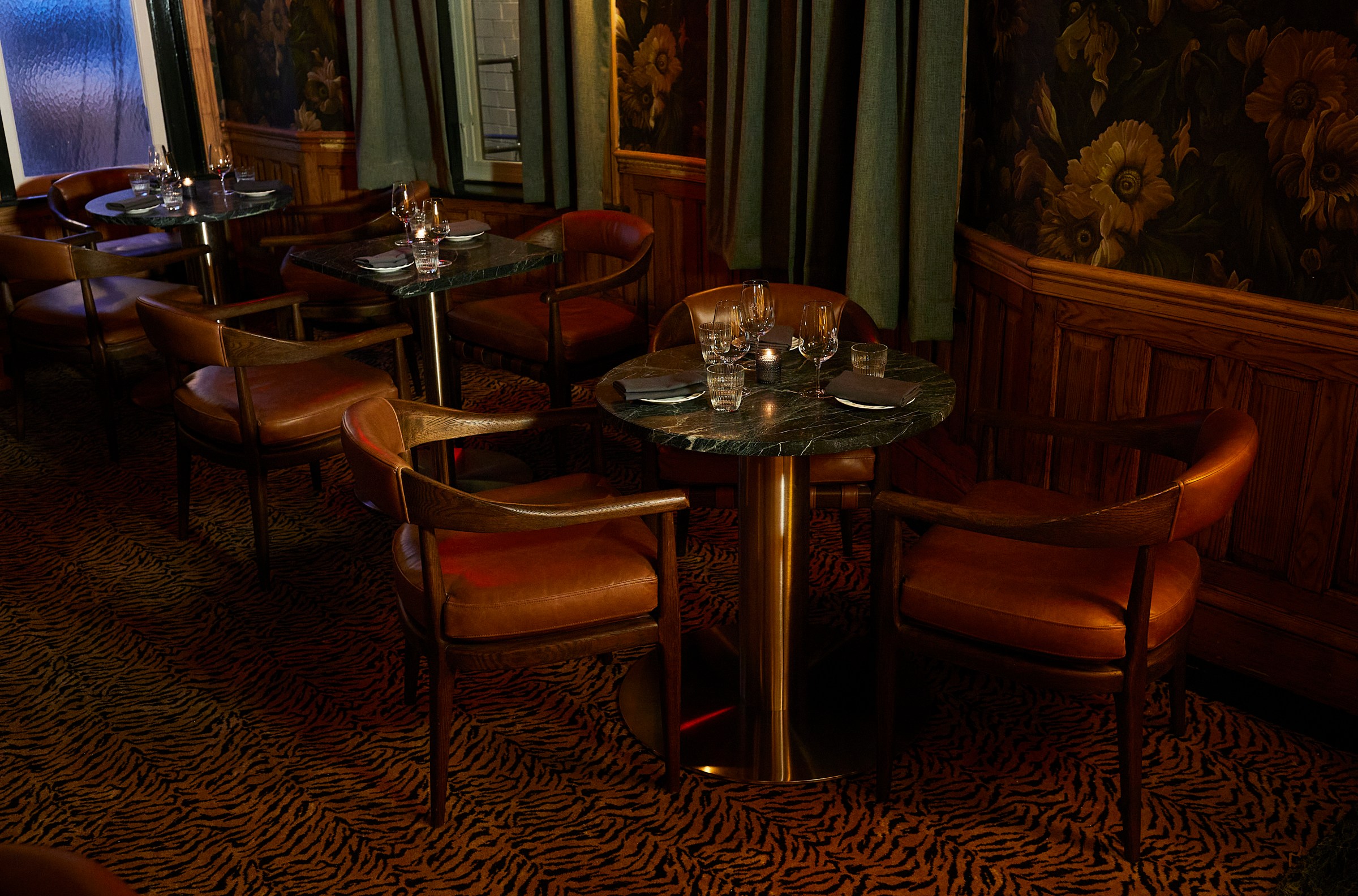 Maison’s lengthy first floor ends with tiger print carpets, candle-lit tables, and dramatic drapes.