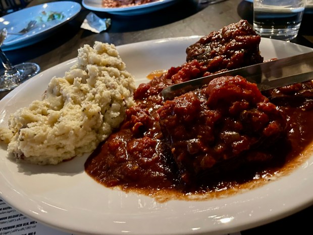 Short ribs in a bright red sauce with a side of mashed potatoes