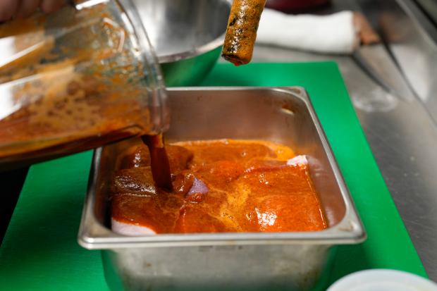 Casillas adds the cochinita marinade to pork in the Puesto...