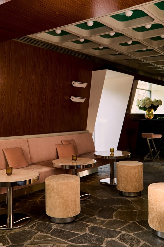 Modern lounge with beige seating, round tables, and contemporary decor.