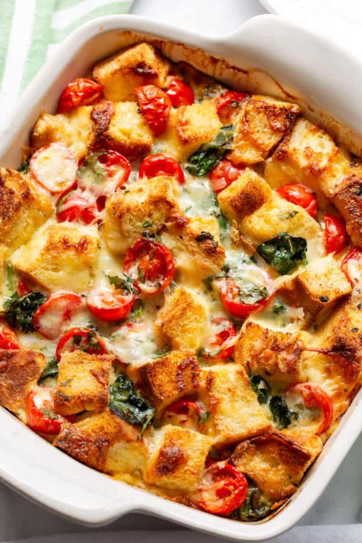 These 35 Scrumptious Make Ahead Brunch Casseroles will make your life over the holidays so much easier. Plus, everyone will be delighted with any one of these casseroles for the holidays. Spinach breakfast strata in dish.