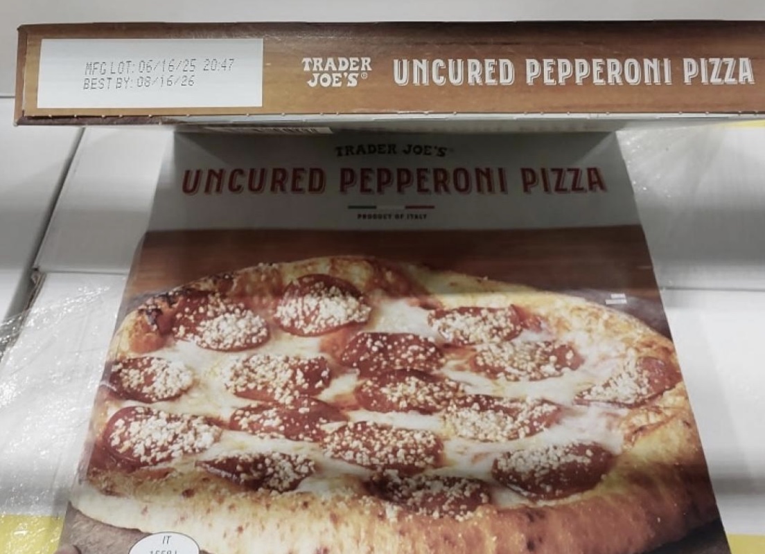 A Trader Joe's boxed uncured pepperoni pizza shows a photo of the pizza topped with pepperoni slices and melted cheese. The box displays the best-by date and product label.