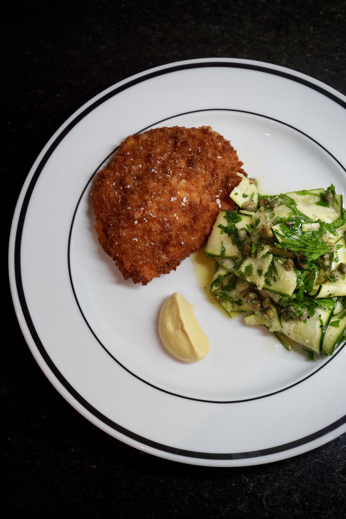 Chicken Kyiv with courgette salad and Dijon mustard.