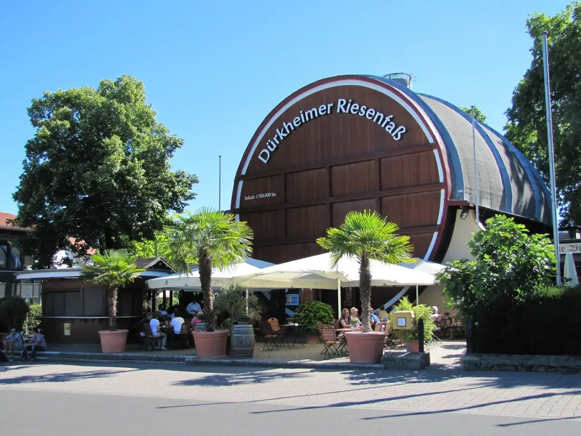 Dürkheimer Riesenfass, the world’s largest wine barrel, in Bad Dürkheim, Germany, with outdoor seating and palm trees