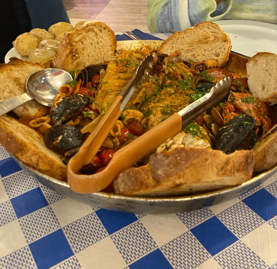 My gf & [I ate] this delicious seafood platter including different mussels, shrimp, squid & crab with tomato sauce & crusty bread