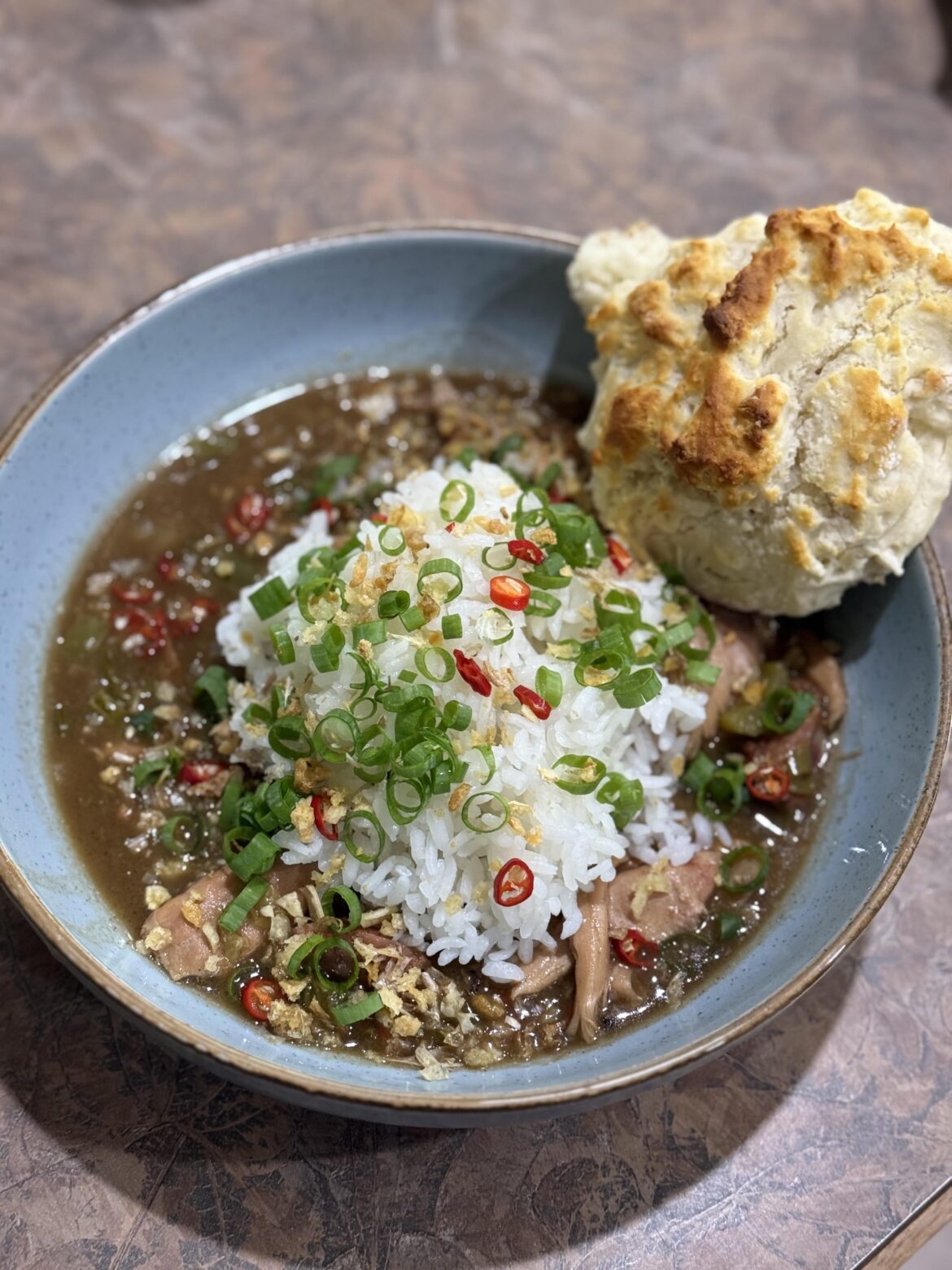 [homemade] some chicken and sausage gumbo with a scratch biscuit. Topped with some Thai chilis from my garden. So good!