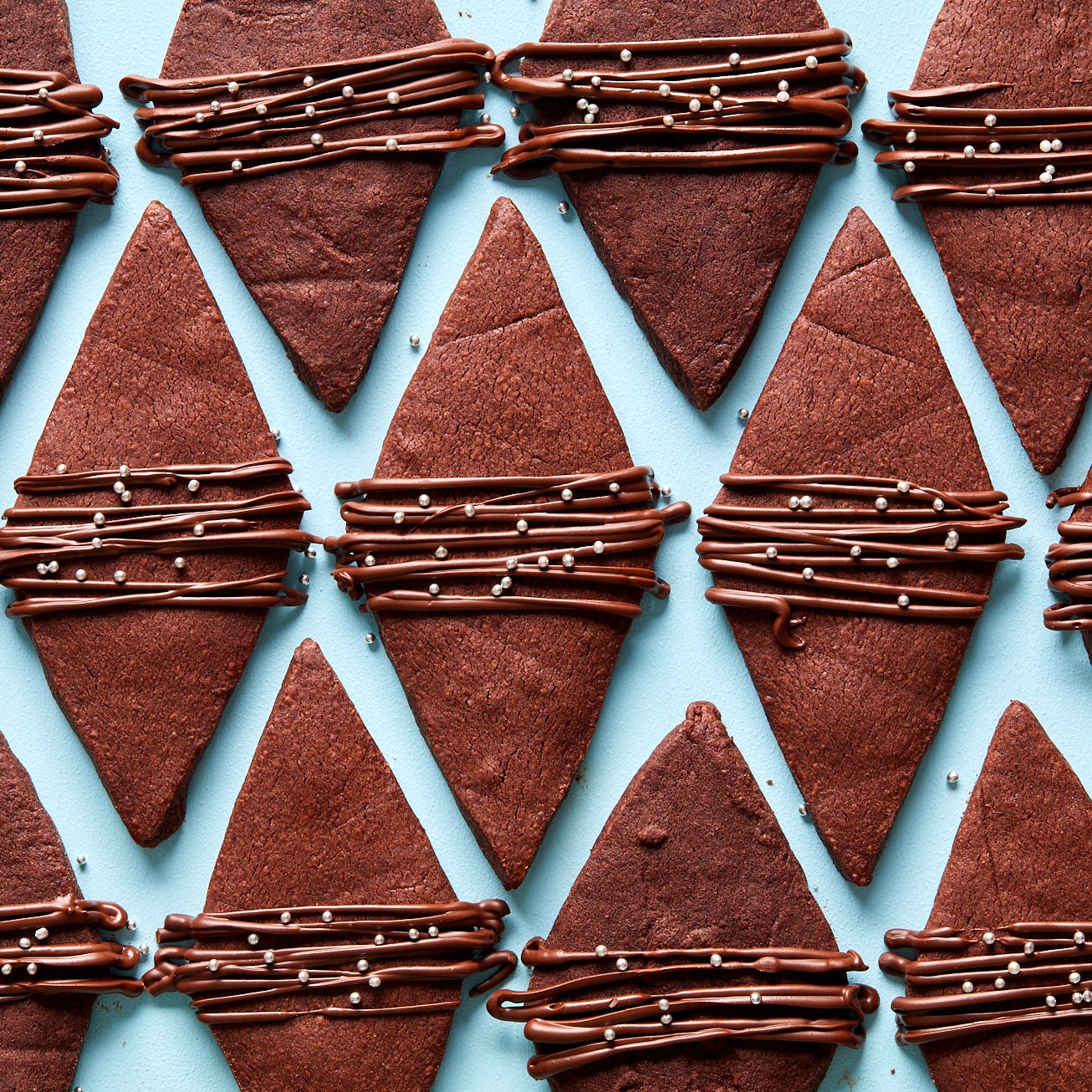 chocolate shortbread cookies shaped like diamonds with a chocolate drizzle