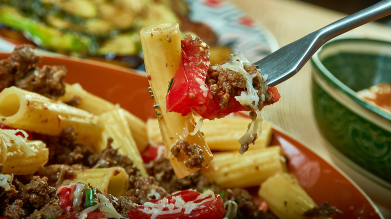 close up forkful of a bowl of cowboy pasta with a noodle, pepper and beef