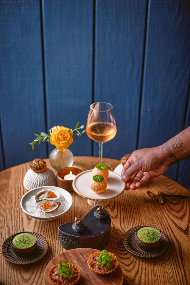 Table Culture Provisions chef Stéphane Saint Louis serves a collage of late spring bites for two, including squid-ink madeleines, asparagus cappuccino, and golden orbs of Indian pani puri filled with Dungeness crab salad. (Kim Carroll/For Sonoma Magazine)