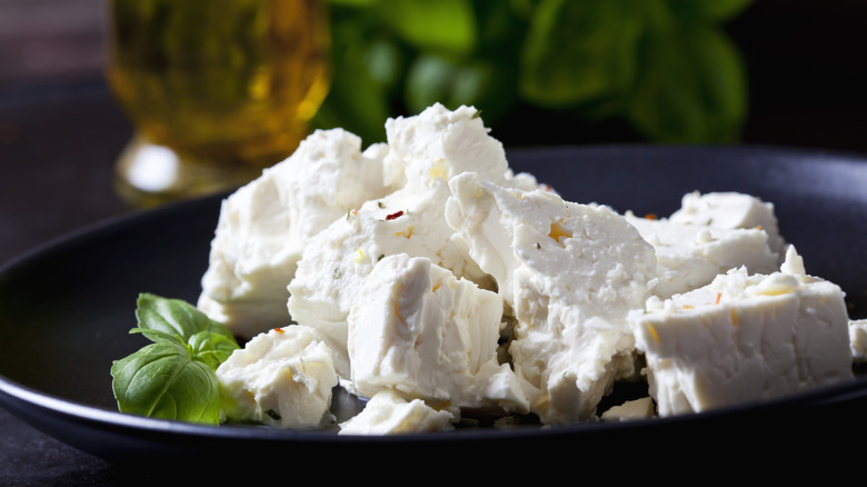 Black bowl full of blocks of feta
