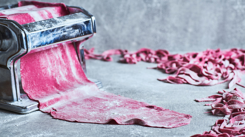 red pasta dough in cutting machine