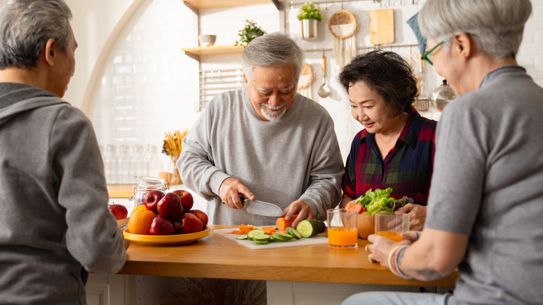 older adult couples preparing a meal in kitchen