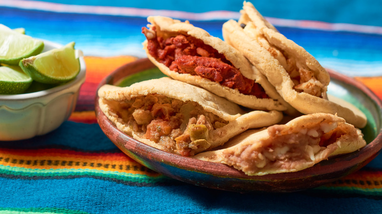 Plate of gorditas next to bowl of limes
