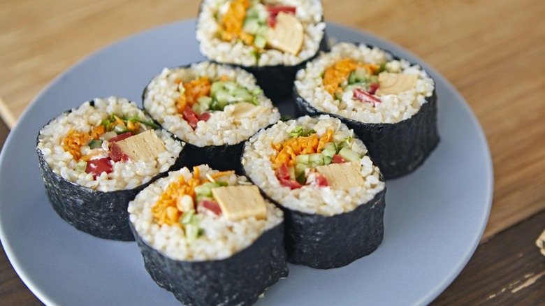 Sushi rolls on blue plate on table