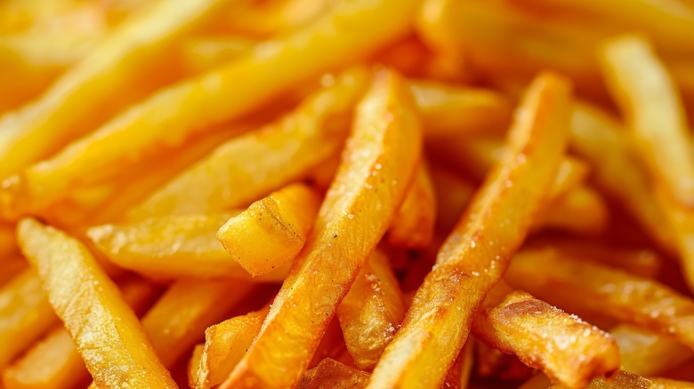 A close-up of salted, crispy French fries in a large pile