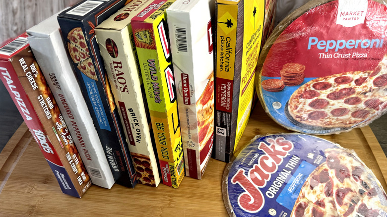 various frozen packaged pepperoni pizzas stacked on table