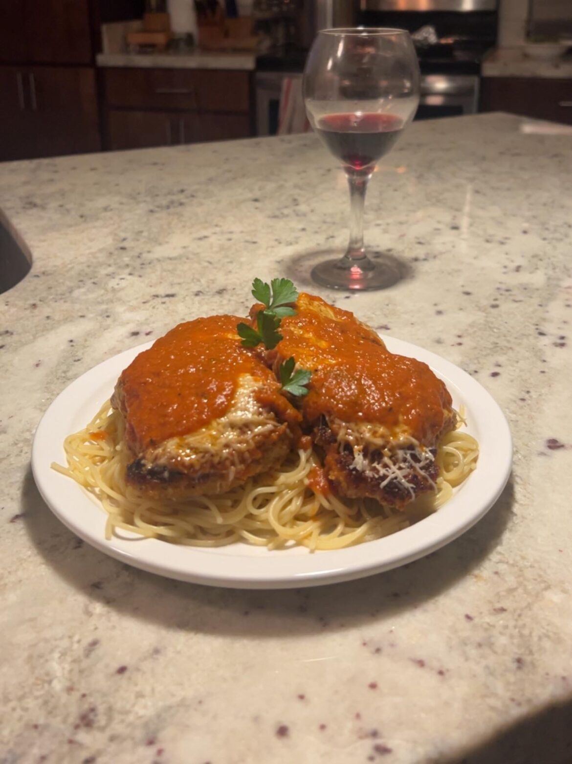 Chicken parmesan with homemade red sauce and a glass of Cabernet