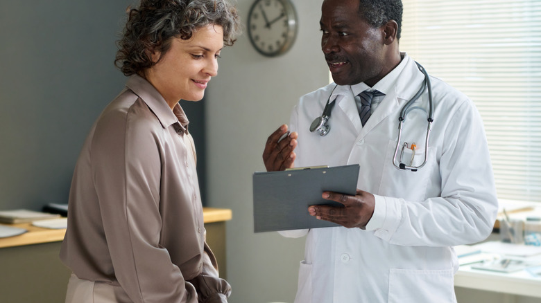 male doctor working with female patient during visit