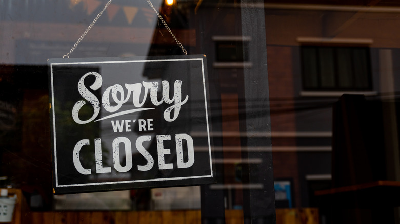 closed sign hangs in window of restaurant