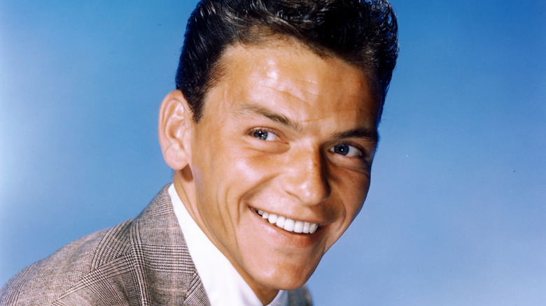 Frank Sinatra smiling and wearing a grey jacket