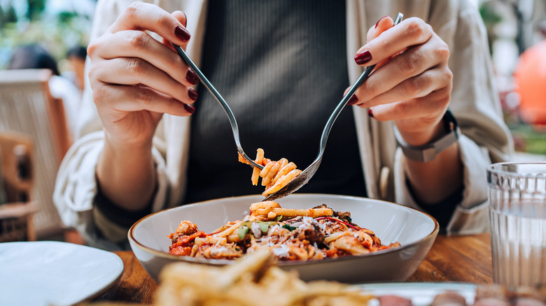 A person eating pasta at a restaurant