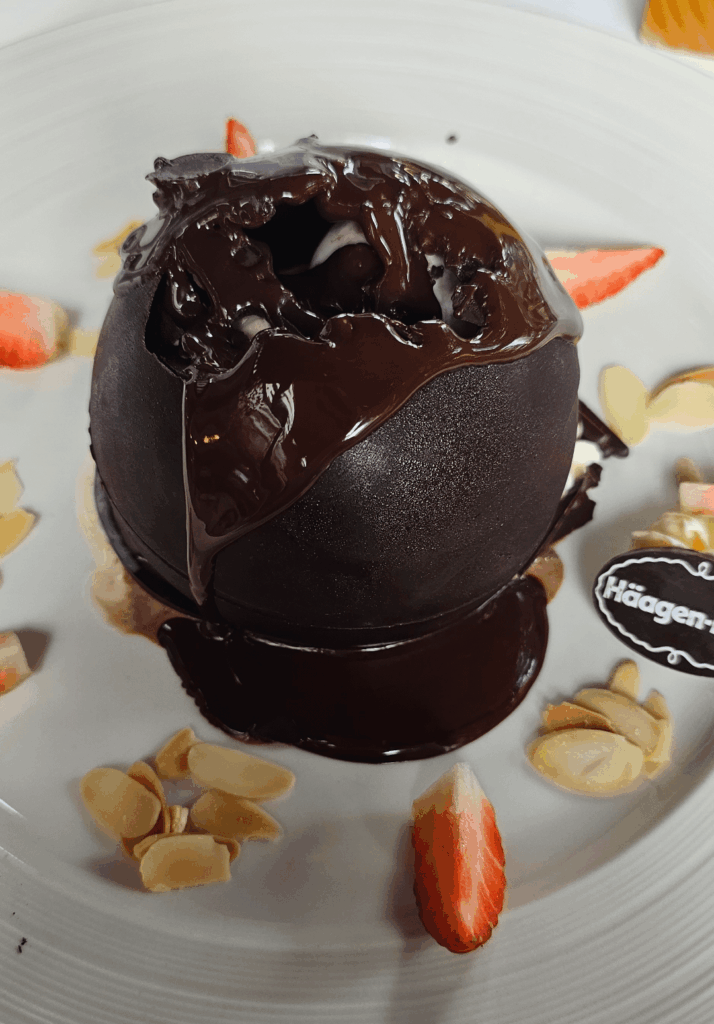Chocolate dome with ice cream inside and melted chocolate poured over the top!