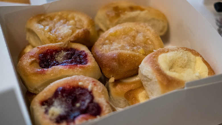 White paper box filled with an assortment of fruit and cheese kolaches.