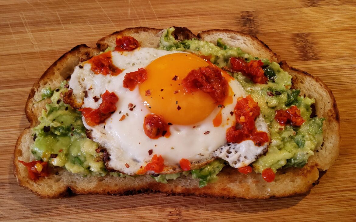 Sourdough toast with guacamole made with 1/2 avocado and fried egg.