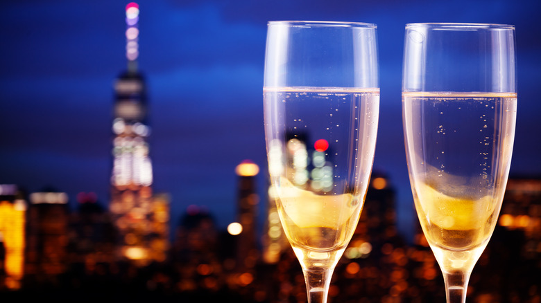 Two glasses of champagne with the Manhattan skyline blurred in the background