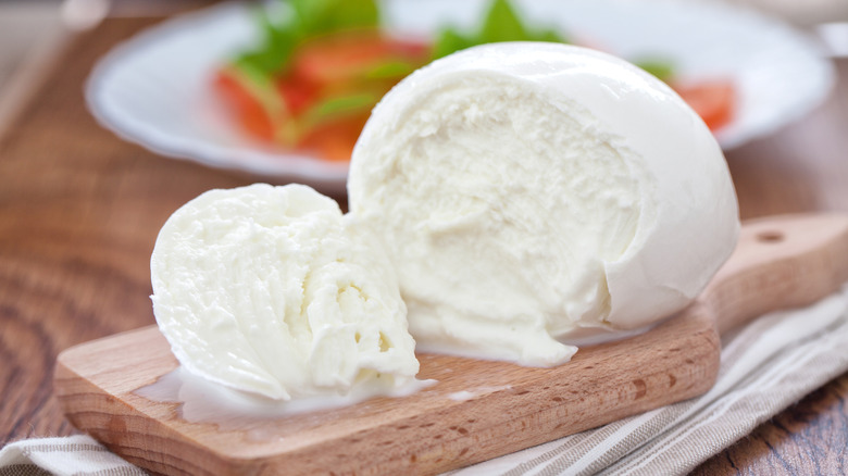 Buffalo mozzarella cut open on a wooded cutting board