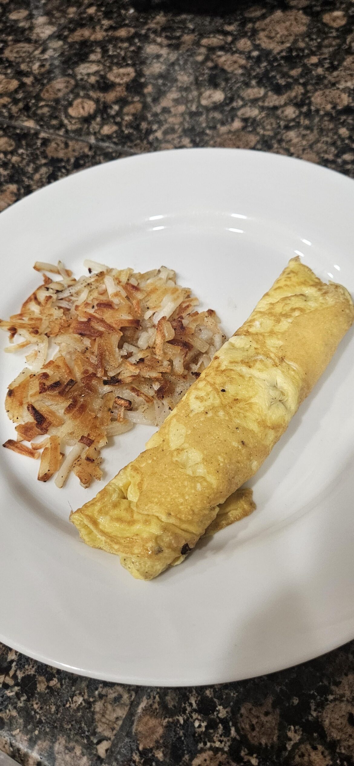 A french onelette with golden hashbrowns.