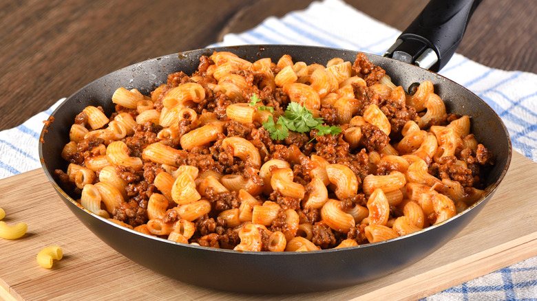 Navy-style macaroni in a black skillet on a wooden board