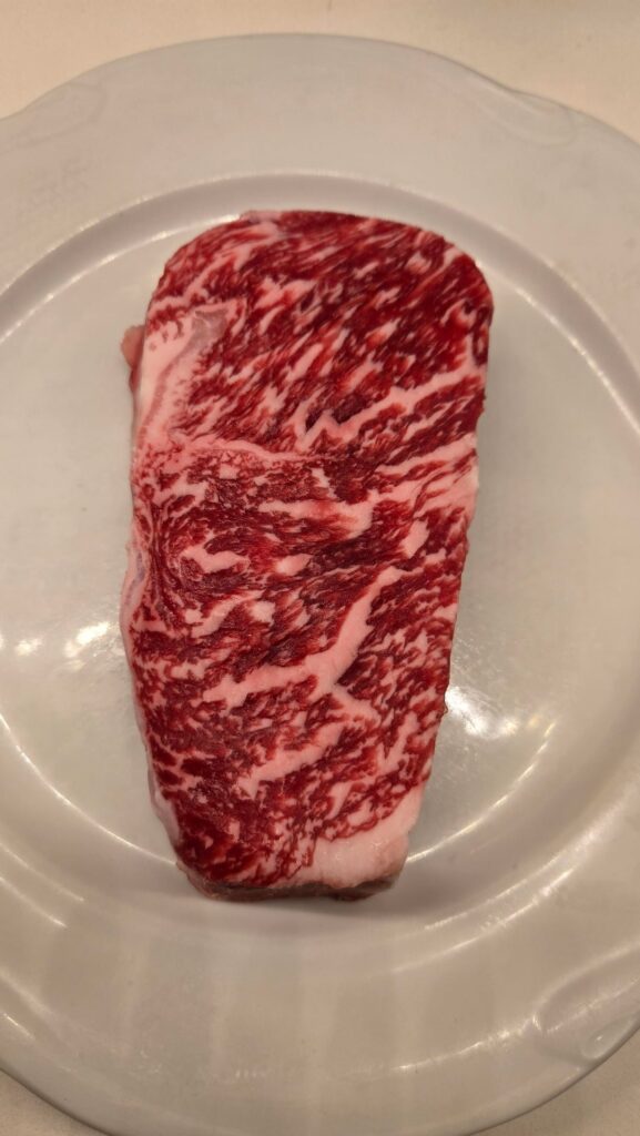 Before and after photos of a Australian wagyu strip steak from Debragga meats.
