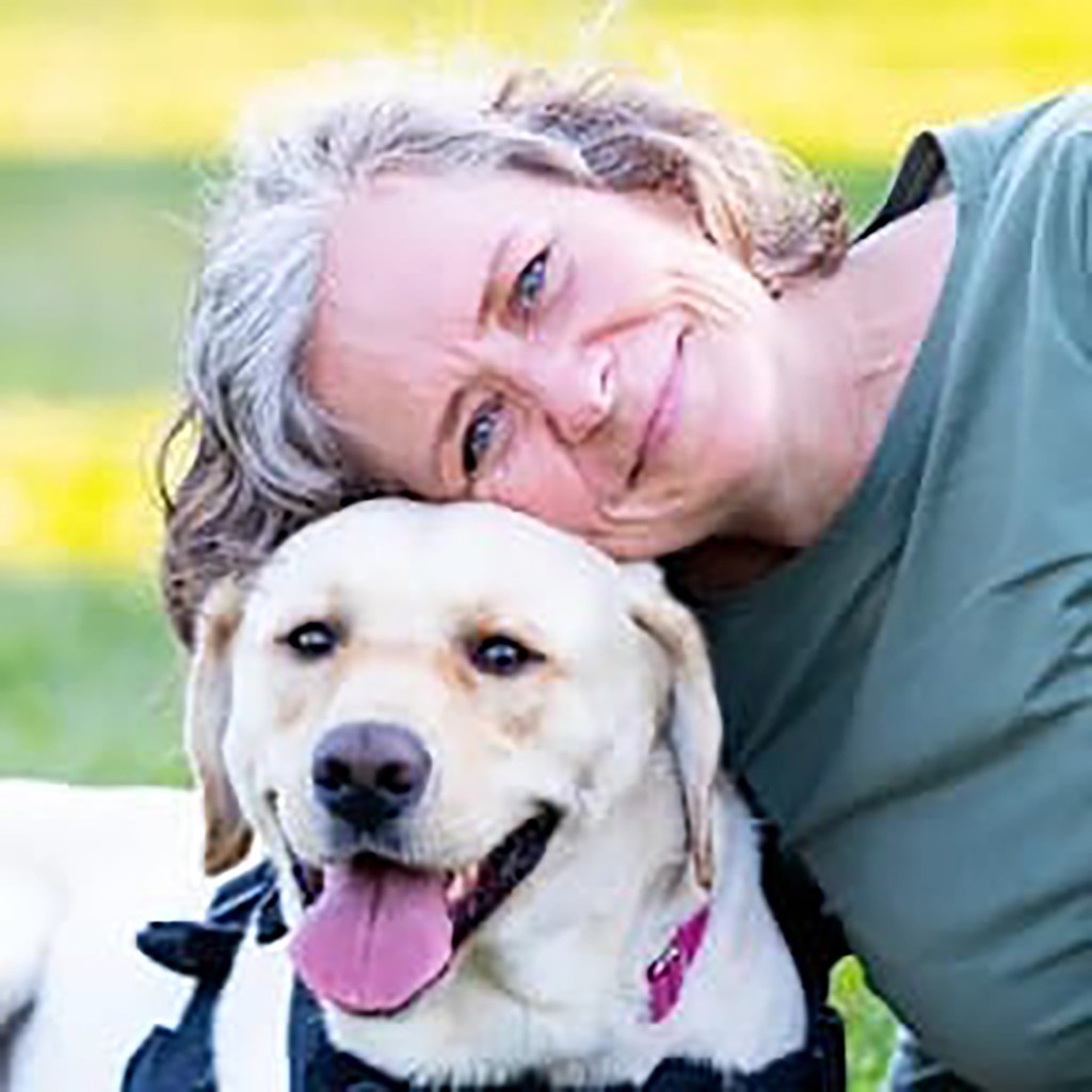 Sarah Van Vooren, a public school teacher in Fayette County, Ky., is seen above with her service dog, a blond Labrador named Mooney.
