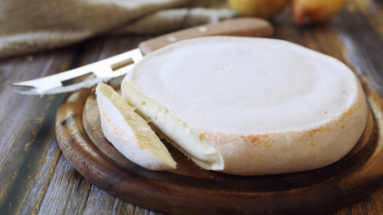 Large wheel of reblochon cheese on a cheese board