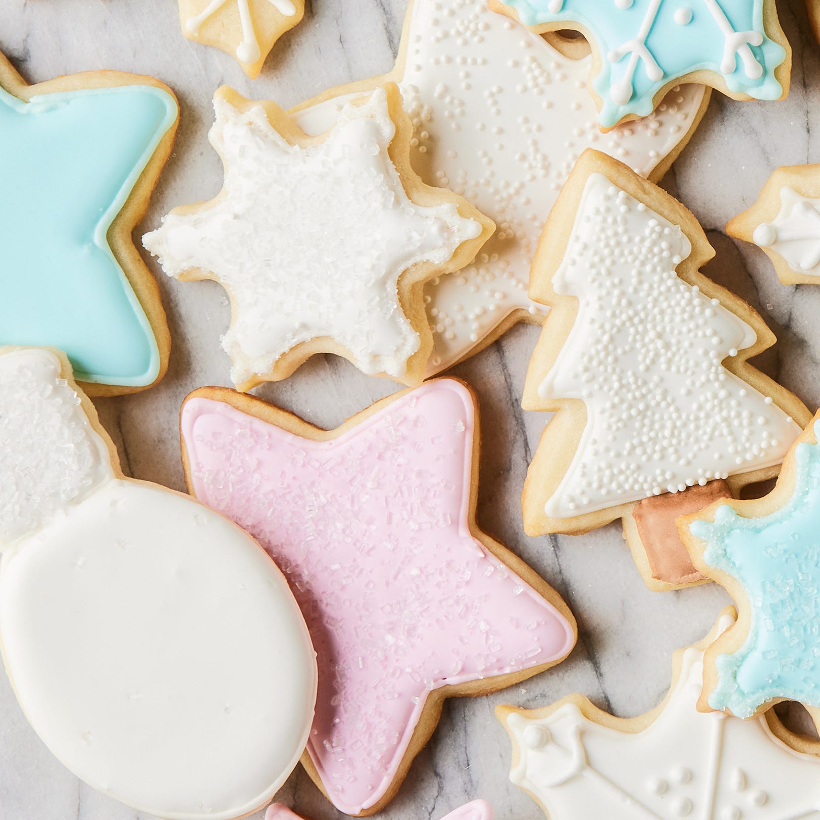 royal icing piped onto cookies with stars and christmas tree shapes