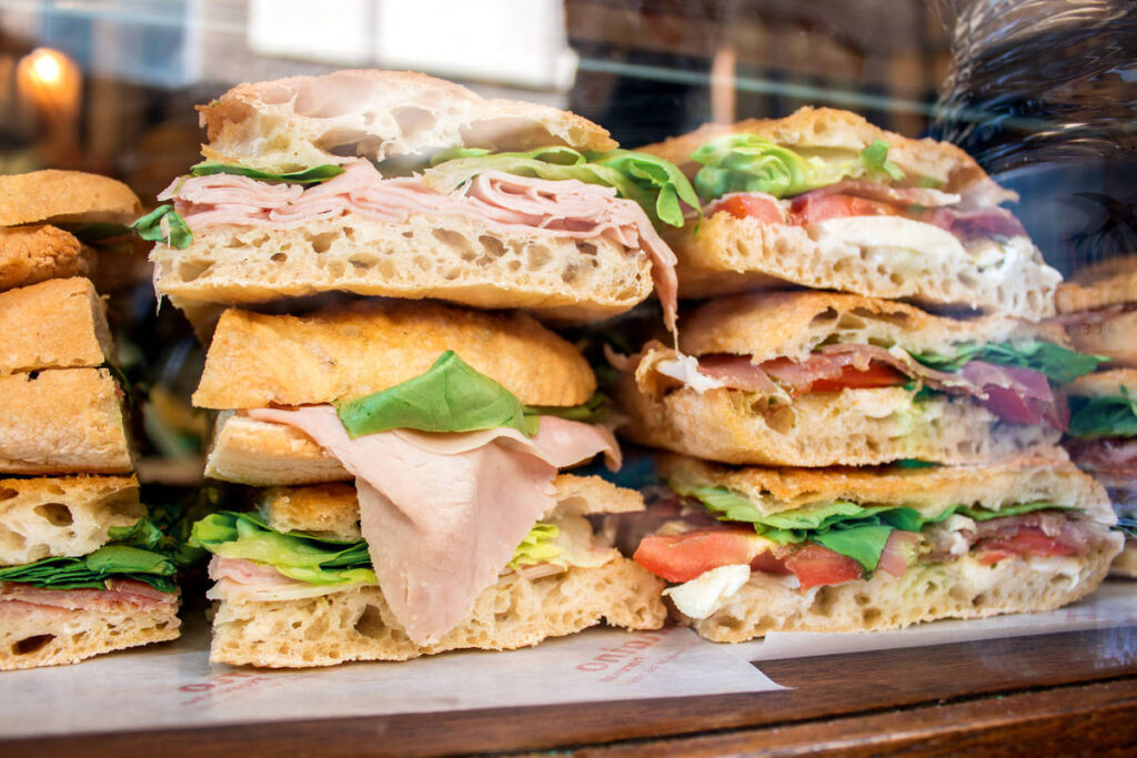 sandwiches stacked on top of each other in the window of All'antico Vinaio