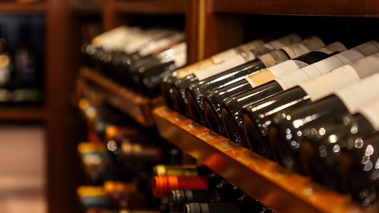 a row of wine bottles on a cellar shelf