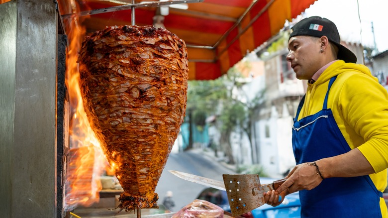Street vendor cooking pork for tacos al pastor