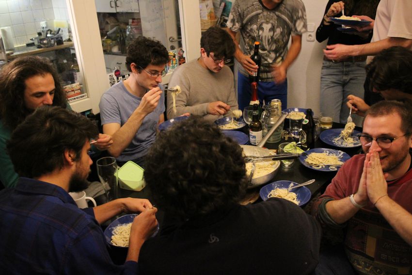 The researchers and their friends sit together eating bowls of cacio e pepe. The researchers and their friends sit together eating bowls of cacio e pepe.
