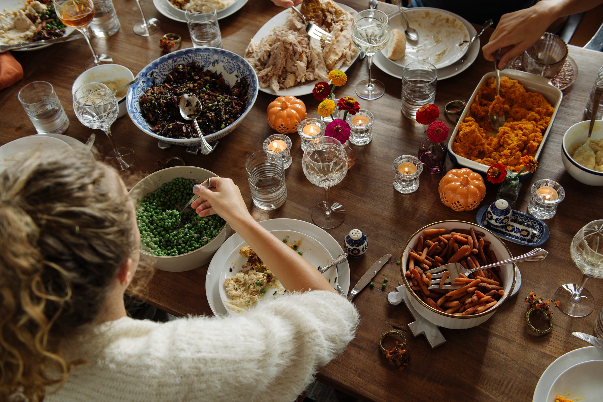 teenage girl having food while sitting at dining table during thanksgiving