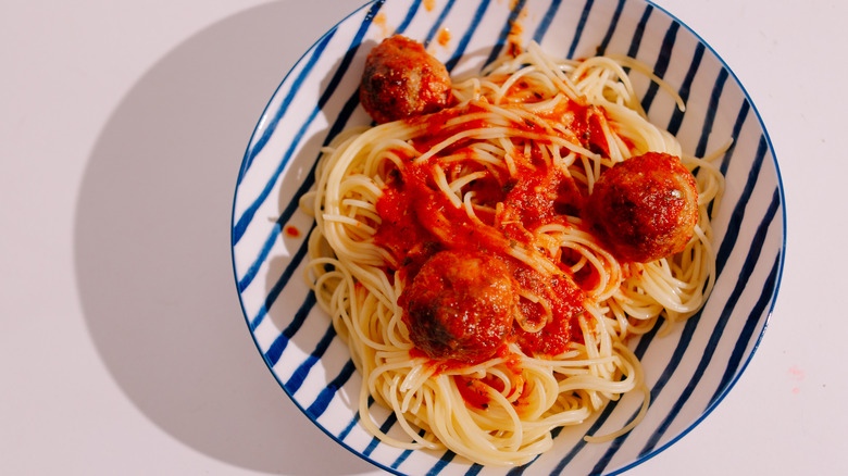 pasta spaghetti with meatballs in striped bowl
