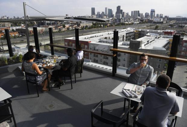 Guests enjoy the view at The Woods restaurant and bar on the rooftop of The Source Hotel August 28, 2018. (Andy Cross, The Denver Post)