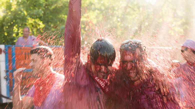 Two men standing side-by-side as they're doused with wine during The Wine Fight in Haro, Spain
